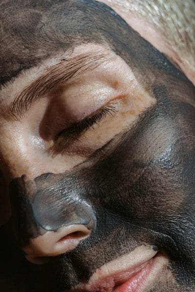 female face wearing a charcoal mask