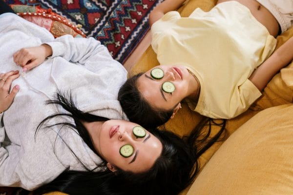 two women with cucumbers on eyes lying down