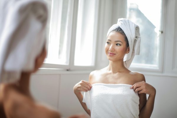 Female in towel looking in mirror