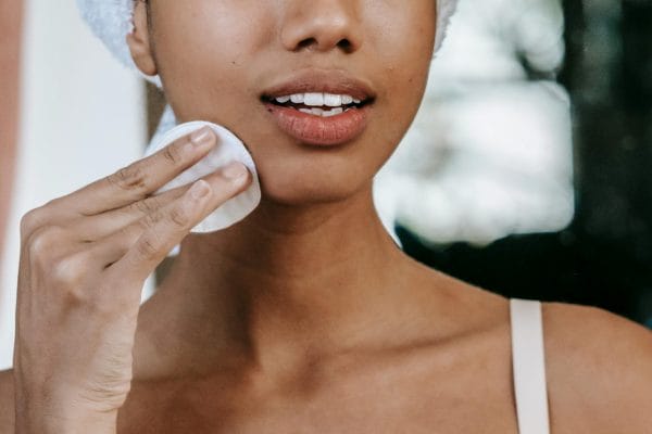 Female using a cotton pad to apply skin toner