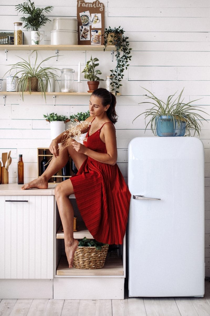 a girl in a red dress sits in the kitchen and hold 2023 11 27 05 05 09 utc