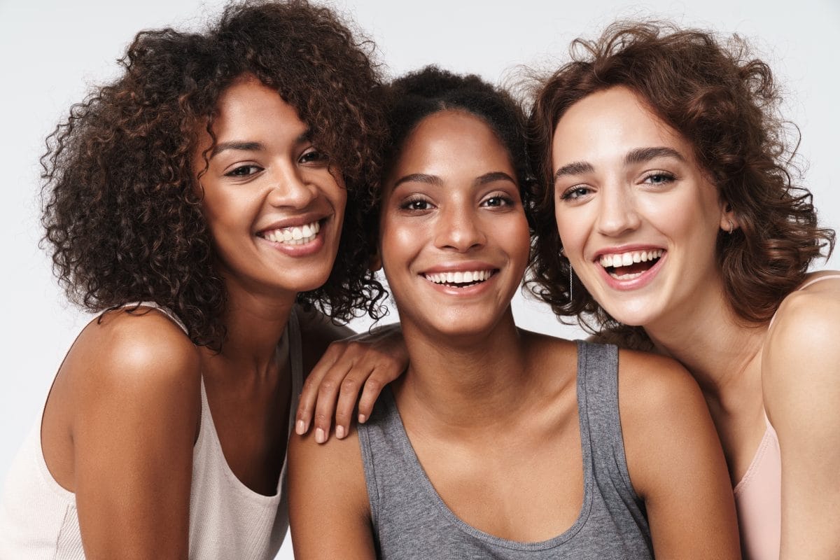 portrait of young multiracial women standing together and smilin