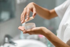 close up of woman hands holding jar with moisturizer cream for face. skincare routine