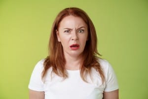 confused shocked gasping middle aged redhead woman cringe frustrated puzzled open mouth speechless freak out strange shocking scene stand green background perplexed disappointed