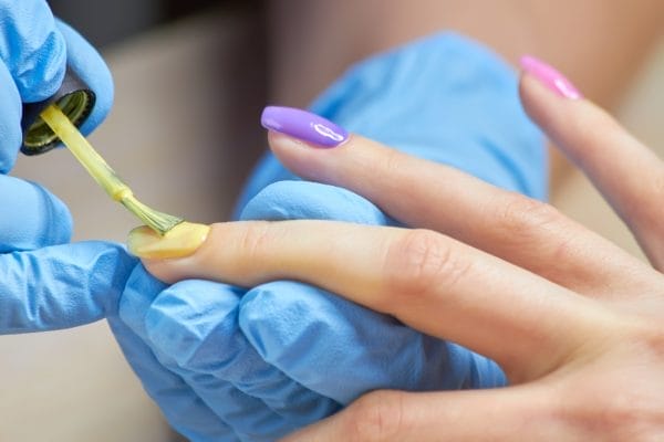 manicure specialist applying varnish to client.