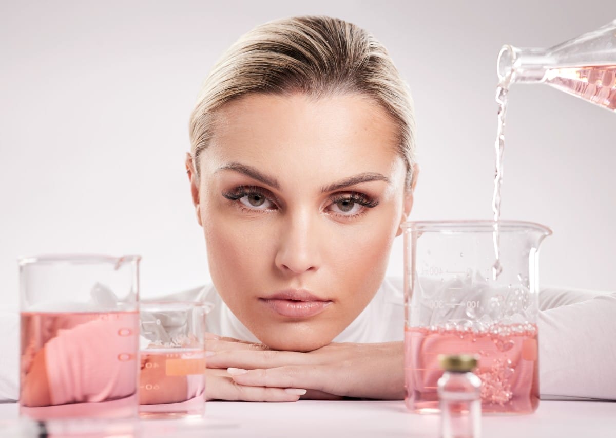 studio shot of young woman making a potion against a white background.