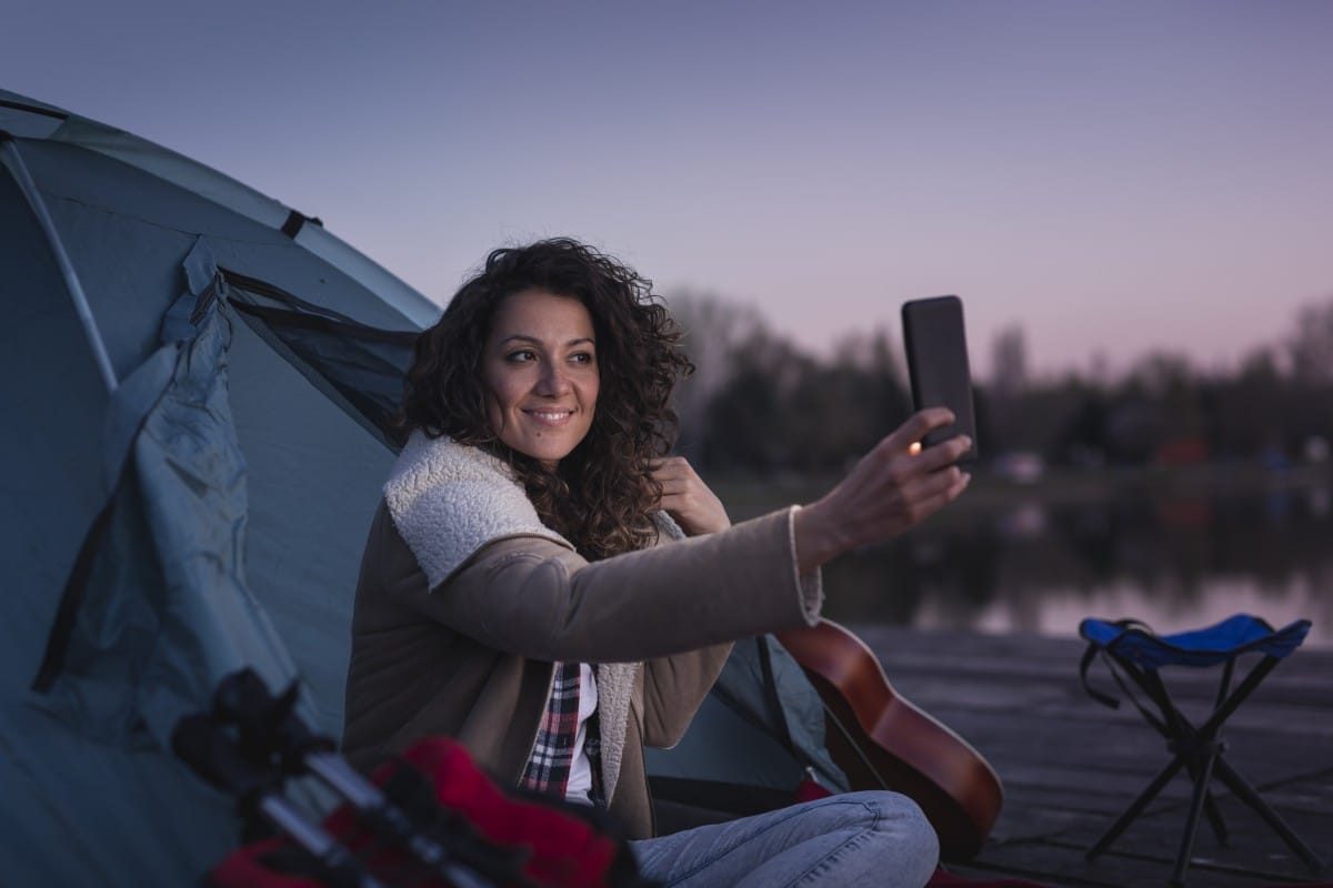 woman camping and taking selfies