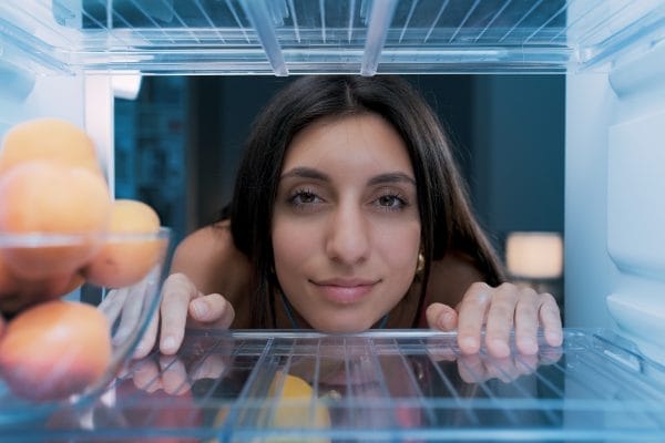 woman cooling herself in the fridge