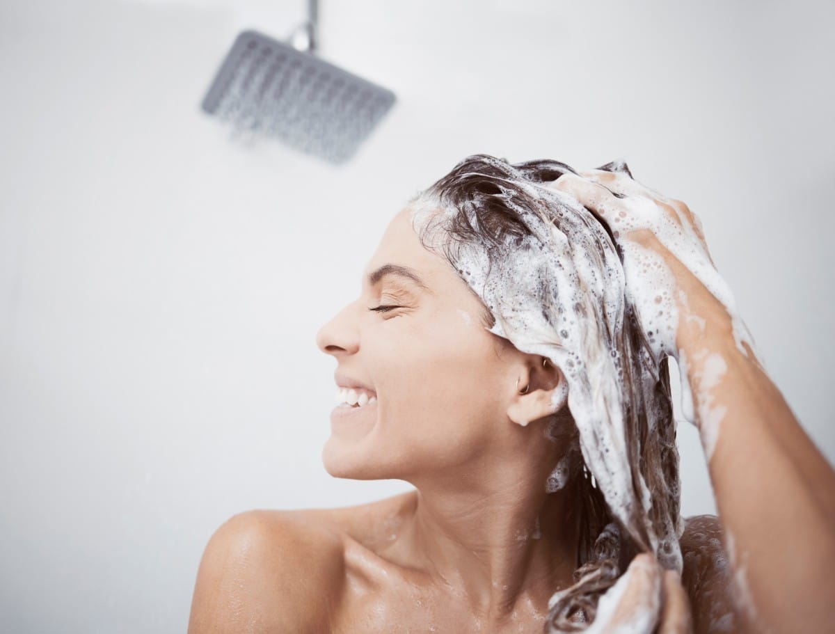 all i want is shiny hair. shot of a woman washing her hair in the shower