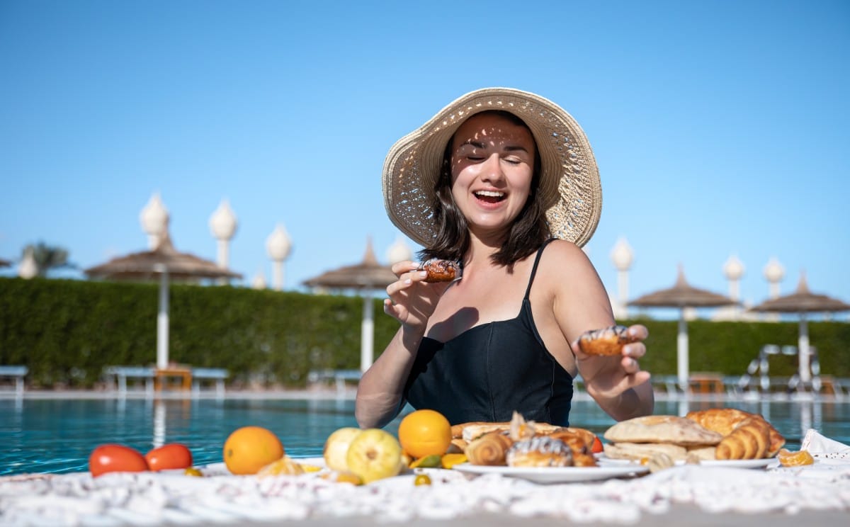 attractive girl enjoying a delicious breakfast in the pool at the resort.