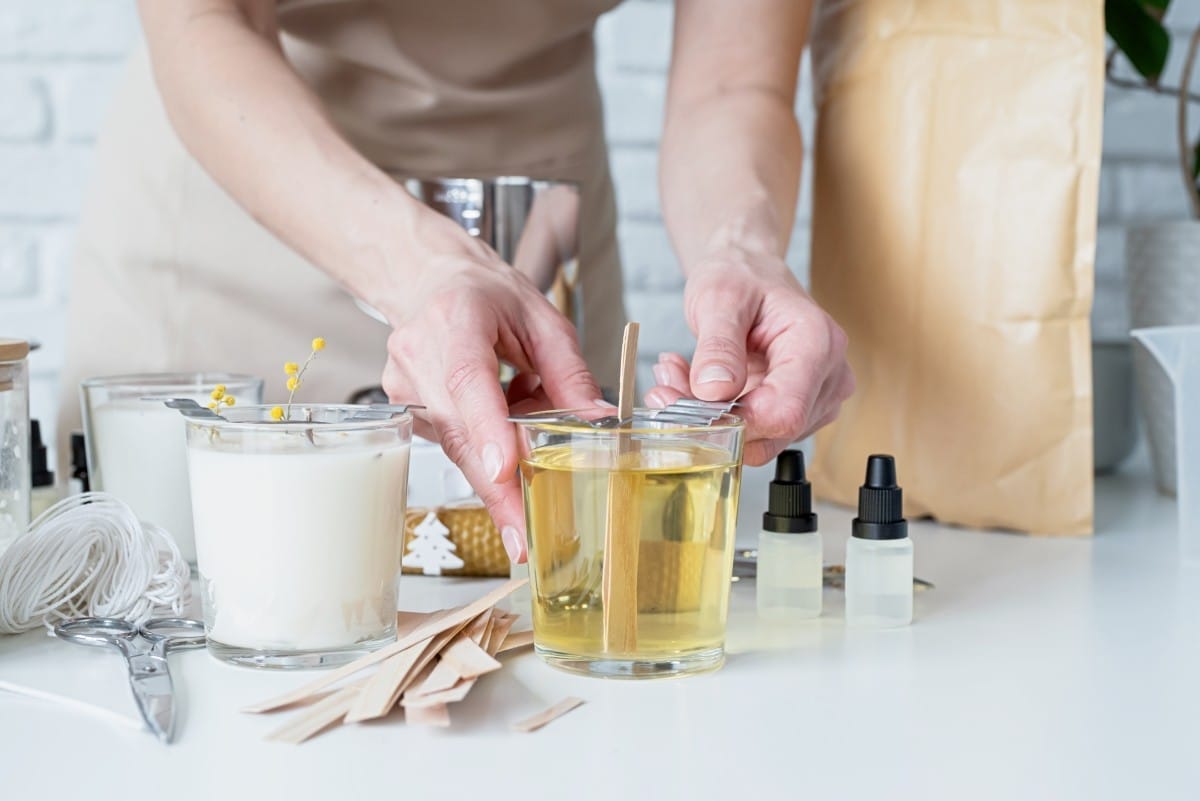 closeup of woman setting the wooden wick into handmade candle