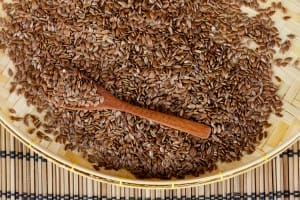 flax seed with spoon placed on flat woven basket