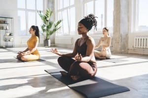 meditating women practicing yoga in studio