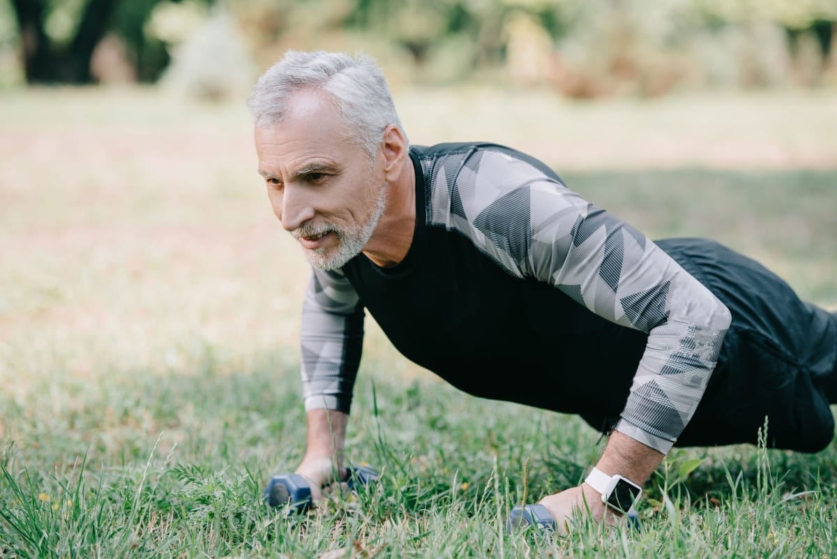 positive mature sportsman doing push ups with barb 2023 11 27 05 32 44 utc