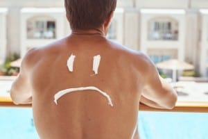 sad smile painted on the man back with sunscreen. sunburn protec