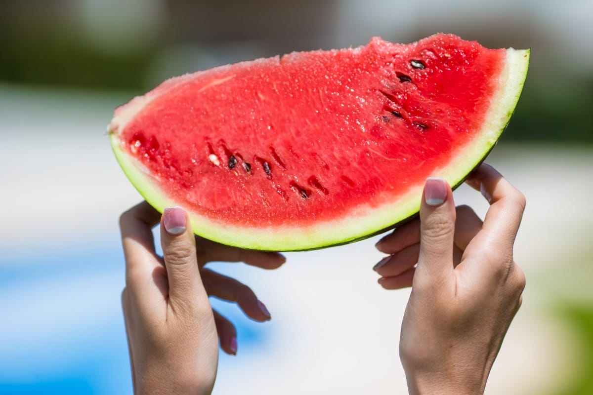 closeup girl female hands with watermelon background swimming pool