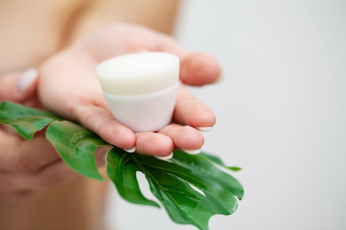 closeup of woman holding face care cream