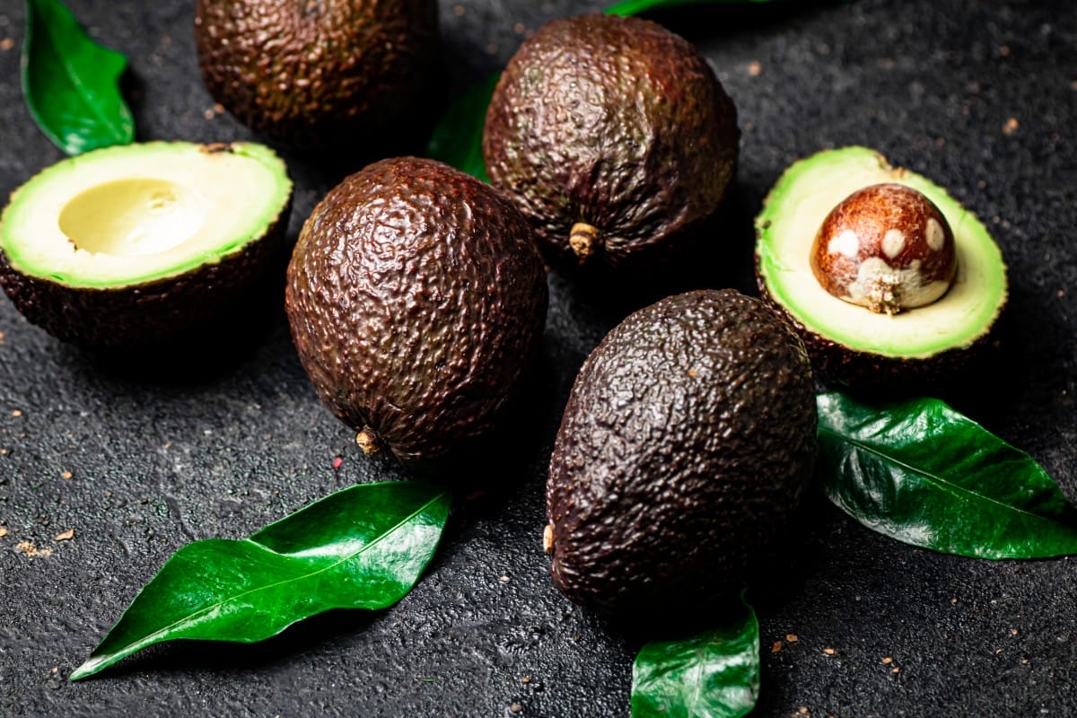 cut ripe avocado with leaves.