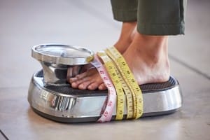 diet weight loss and feet of a woman on a scale f 2023 11 27 05 03 17 utc