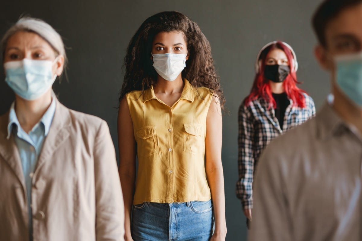 multiracial man and women in face mask looking at camera