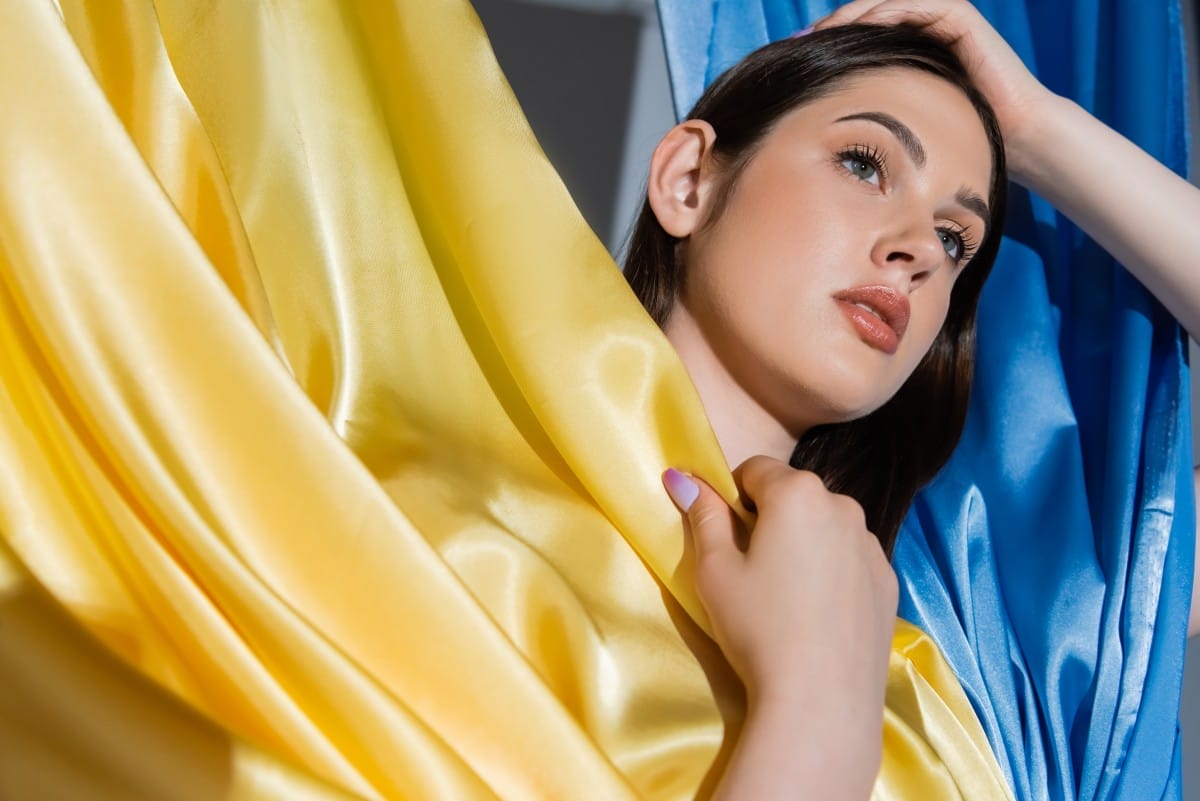 portrait of brunette ukrainian woman posing near national blue and yellow flag