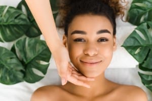 relaxed woman lying with tropical leaves around