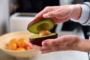 ripe avocado in woman hands, healthy breakfast