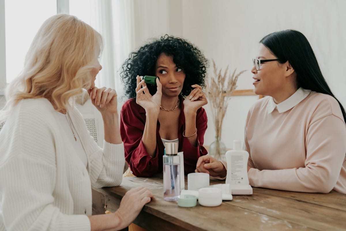 three mature women discussing beauty treatments while sitting at the desk together