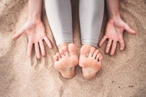 top view of woman practicing yoga on the beach.