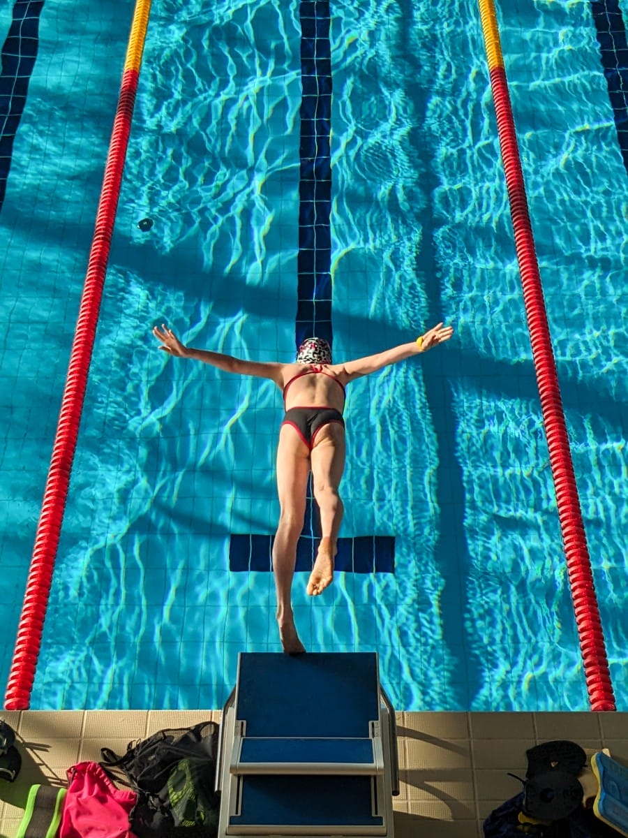 swimmer girl start from the starting table in the pool