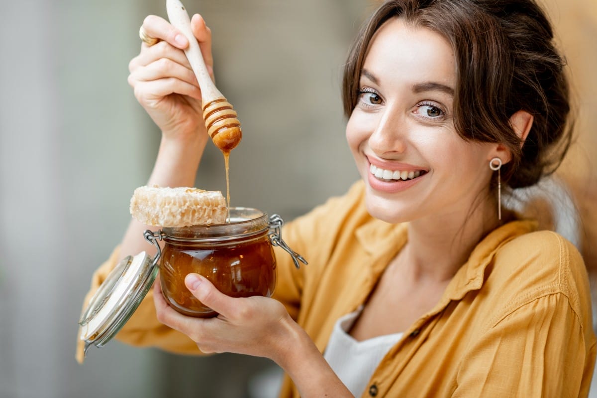 woman eating honey at home