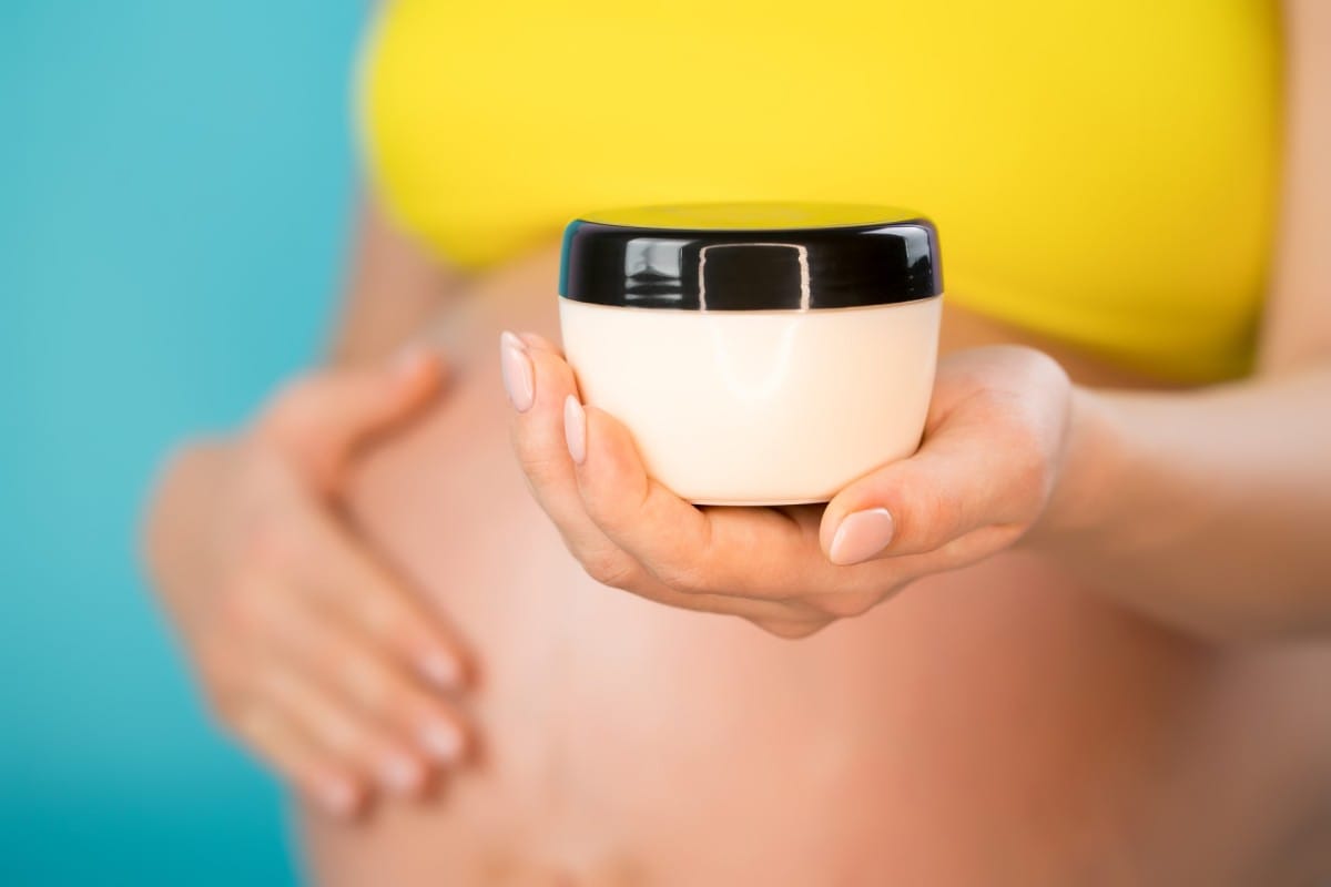 pregnant woman applying moisturizing cream against 2023 11 27 04 48 55 utc