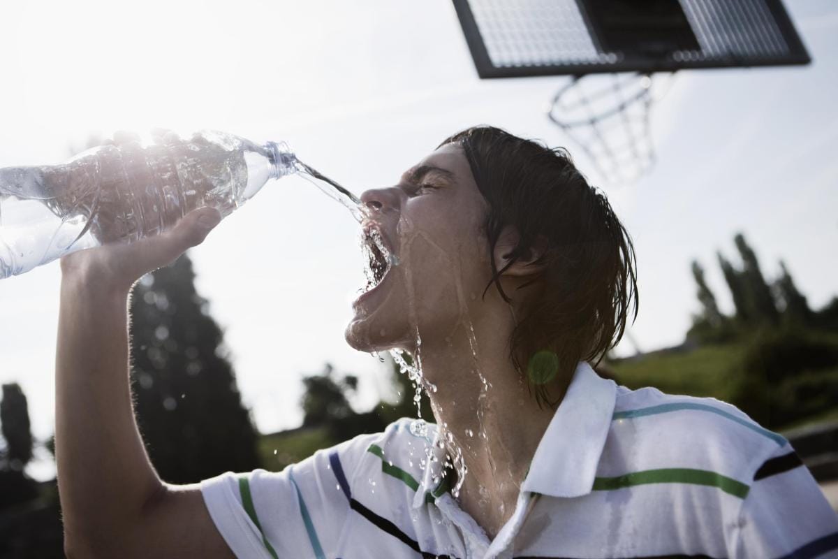 germany berlin teenage boy pouring bottled water 2024 09 18 21 22 49 utc