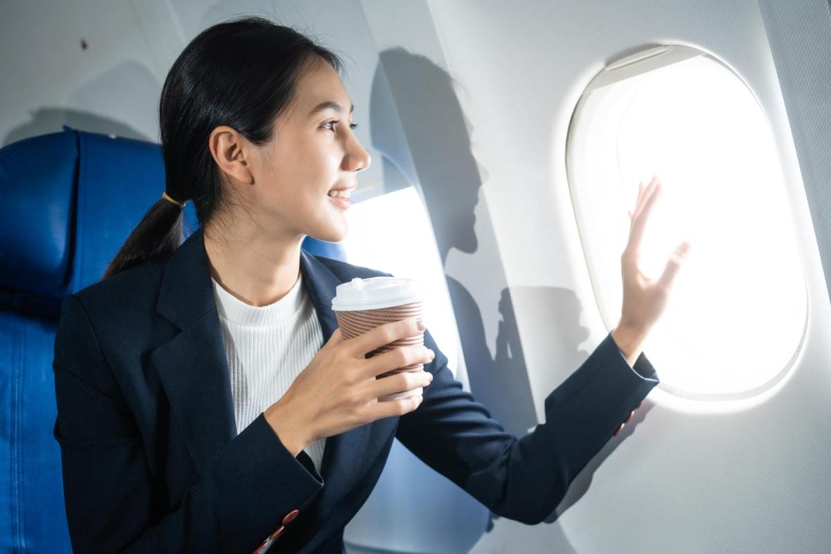 woman in a formal suit sits in a window seat of an 2024 06 28 15 55 20 utc