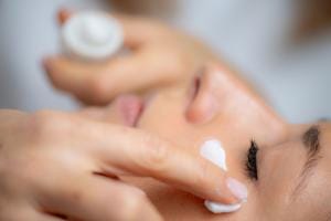 Woman applying facial cream for skincare routine