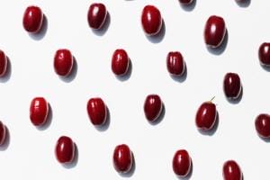 Multiple shiny red cherries on white background