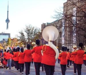 Marching band parades downtown with Toronto's CN Tower backdrop