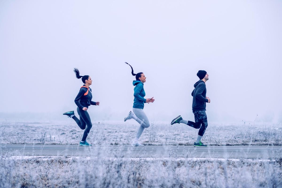 Three people jogging in a frosty landscape