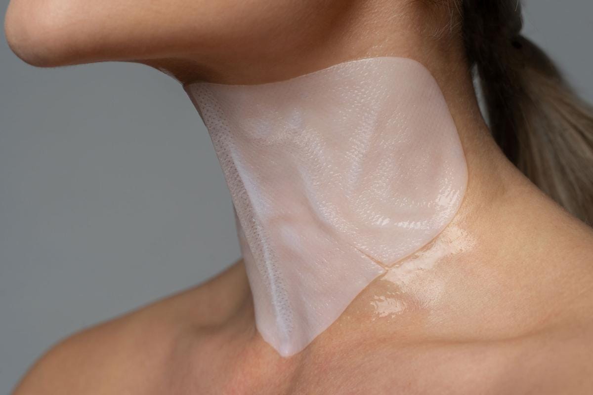 Woman applying transparent neck skincare patch