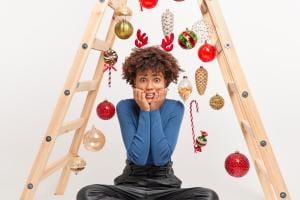 Excited woman with festive Christmas decorations on ladder