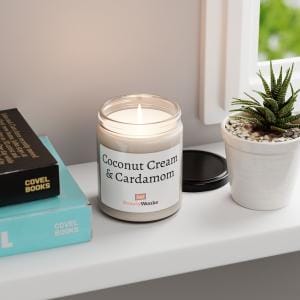 Lit coconut cream and cardamom candle on window sill