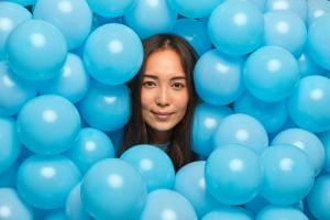 Woman surrounded by blue balloons