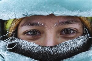 Close-up of eyes with frost, wrapped in winter gear