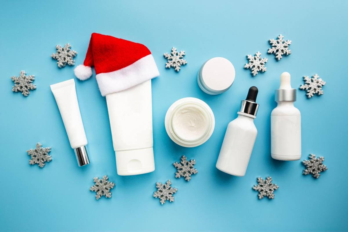 Holiday skincare products with Santa hat on blue background