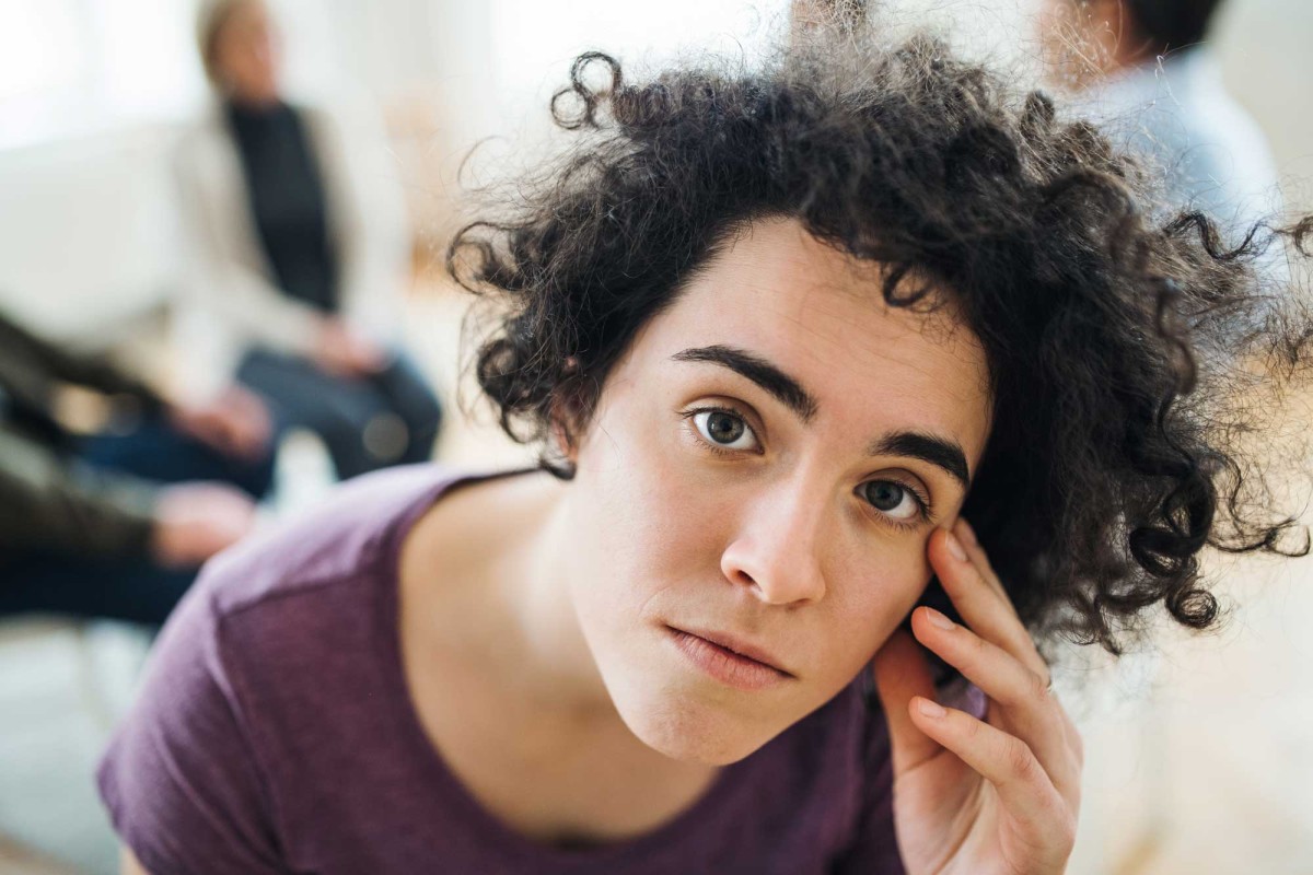 Young woman pondering in group session