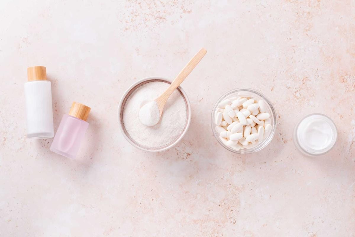 Skincare products with powder and pills on marble surface