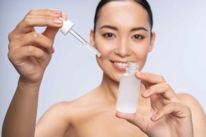 Woman demonstrating skincare serum with dropper