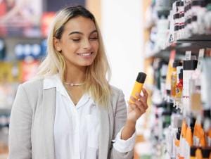 Woman examining cosmetics in a store aisle