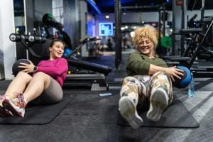 Two women smiling during gym workout session