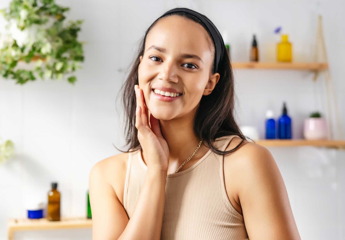 Smiling woman touching face in bright bathroom setting